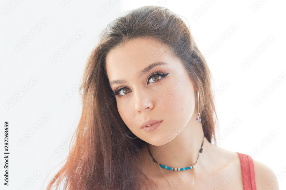 Serious young woman without makeup on a white background