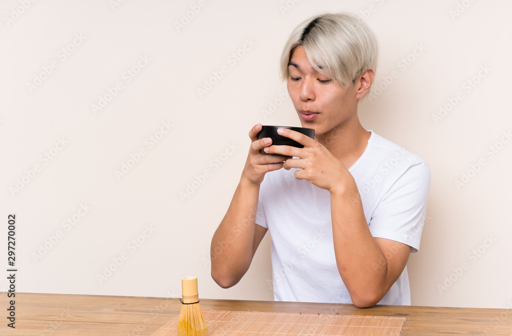 Young asian man with matcha tea in a table Young asian man with matcha tea in a table