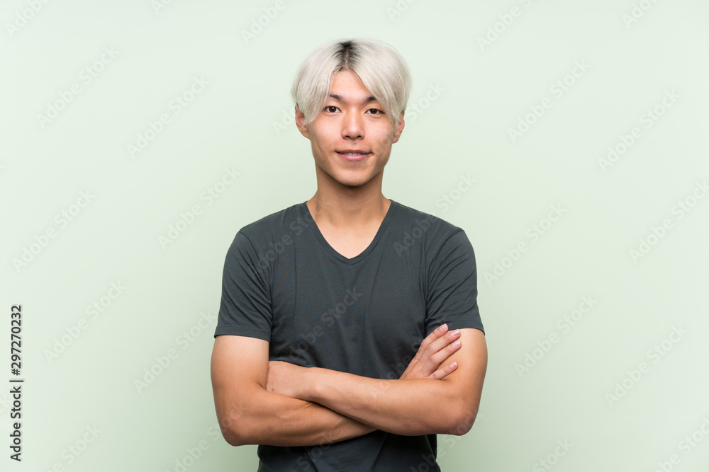 Φωτογραφία Young asian man over isolated green background keeping the arms crossed in front