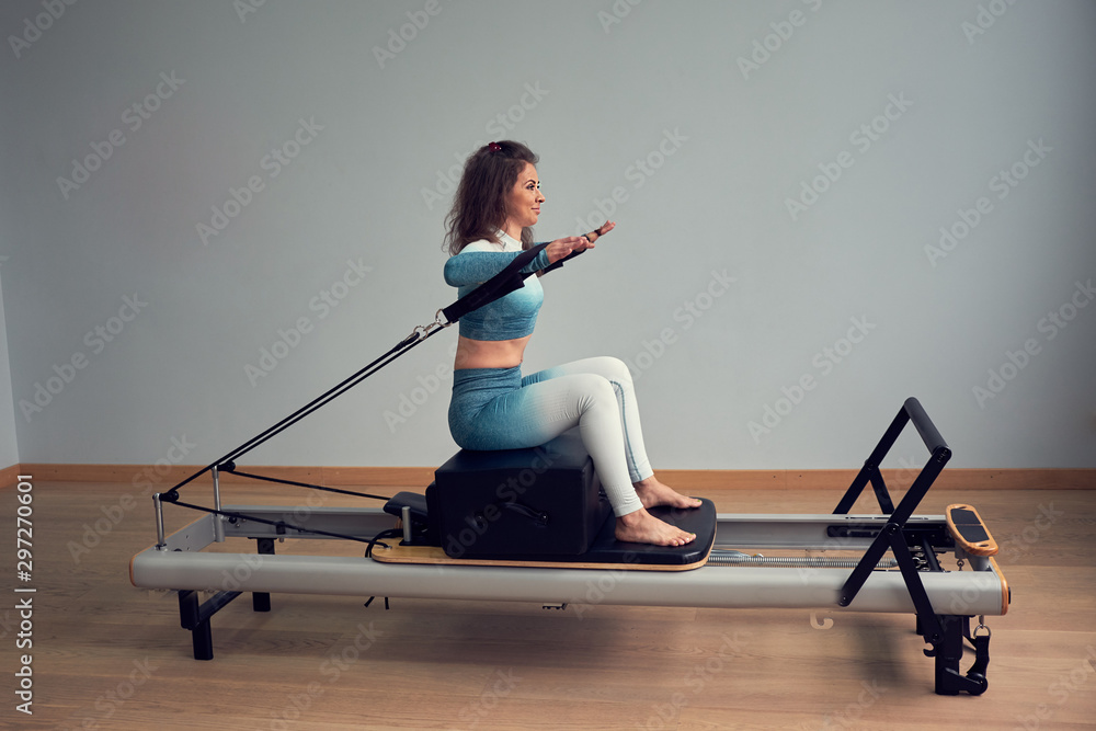 leotard workout pilates training. athletic pilates reformer exercises.  pilates machine equipment. young asian woman pilates stretching sport in reformer  bed instructor girl in a studio Stock Photo