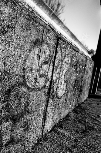 Grafitti seen on a pre-fab concrete wall located in an area of rioting and national unrest in Europe. photo