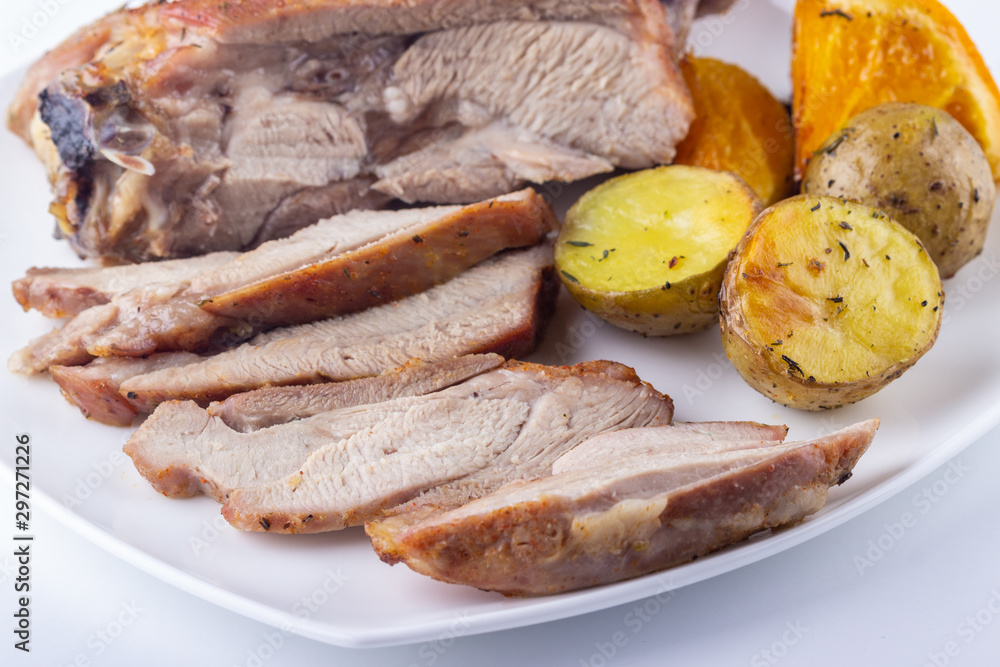 Baked turkey thigh with oranges and potatoes closeup Baked turkey thigh with oranges and potatoes closeup