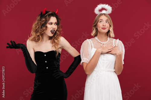 Demon and cute angel in carnival costumes