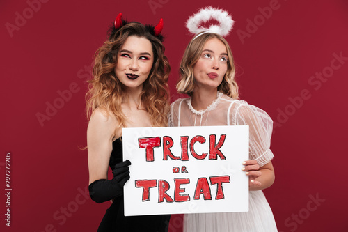 Women demon and angel in carnival costumes photo