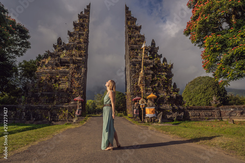 Tourist woman walking through Traditional Balinese Hindu gate Candi Bentar close to Bedugul, Bratan lake Bali island Indonesia. Vacation on Bali photo