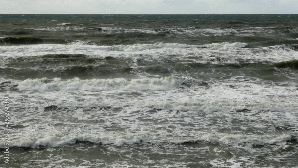 Slow motion shot of Baltic sea waves under grey sky during cold weather. Low angle shot. Slow motion shot of Baltic sea waves under grey sky during cold weather. Low angle shot.