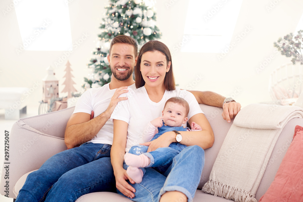 Lovely family with their baby girls relaxing on sofa at home Lovely family with their baby girls relaxing on sofa at home