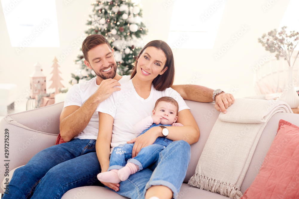 Lovely family with their baby girls relaxing on sofa at home Lovely family with their baby girls relaxing on sofa at home