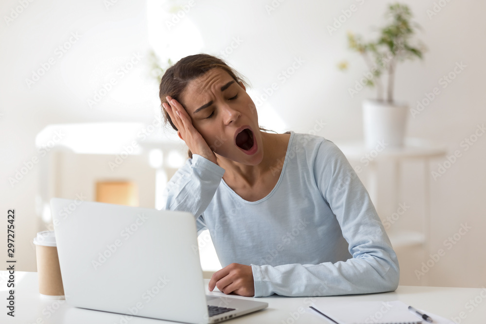 Tired young mixed race female worker yawning. Tired young mixed race female worker yawning.