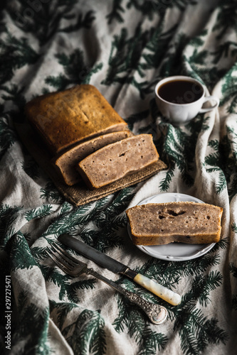 Sliced banana bread, a cup of black coffee, fork and knife. Vertical