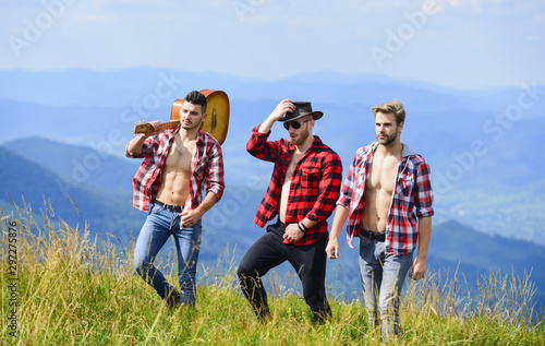 love is music. men with guitar in checkered shirt. western camping. campfire songs. happy men friends with guitar. friendship. hiking adventure. cowboy men. group of people spend free time together © be free