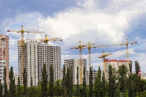 Construction of a high-rise building, construction crane. Blue sky background.