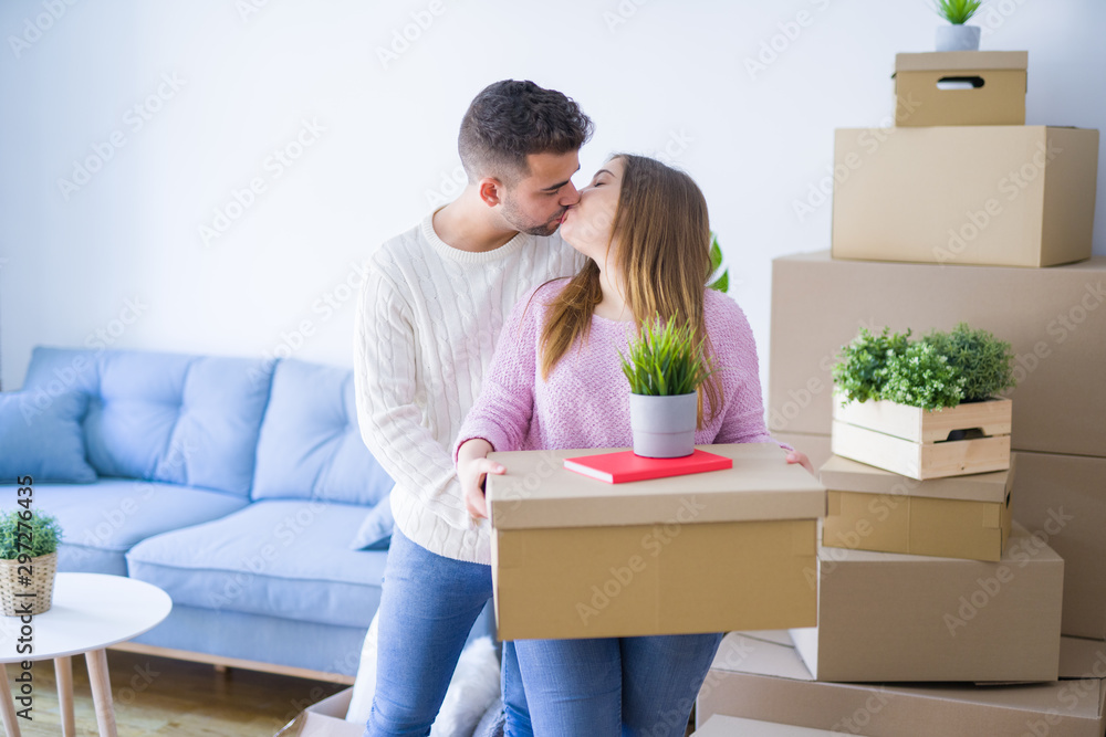 Young beautiful couple in love moving to new home, holding cardboard boxes very happy and cheerful for new apartment Young beautiful couple in love moving to new home, holding cardboard boxes very happy and cheerful for new apartment