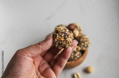 Energy ball in women`s hands. Homemade organic dessert with dates, nuts and cocoa