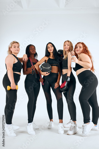 Young attractive girls in black sportswear stand together, promote sport life, healthy lifestyle concept, sport