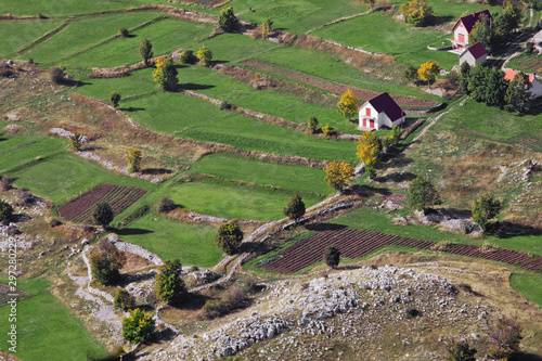 cozy white lonely reclusive house surrounded by green fields in early autumn, Montenegro. A symbol of happiness and family values. photo