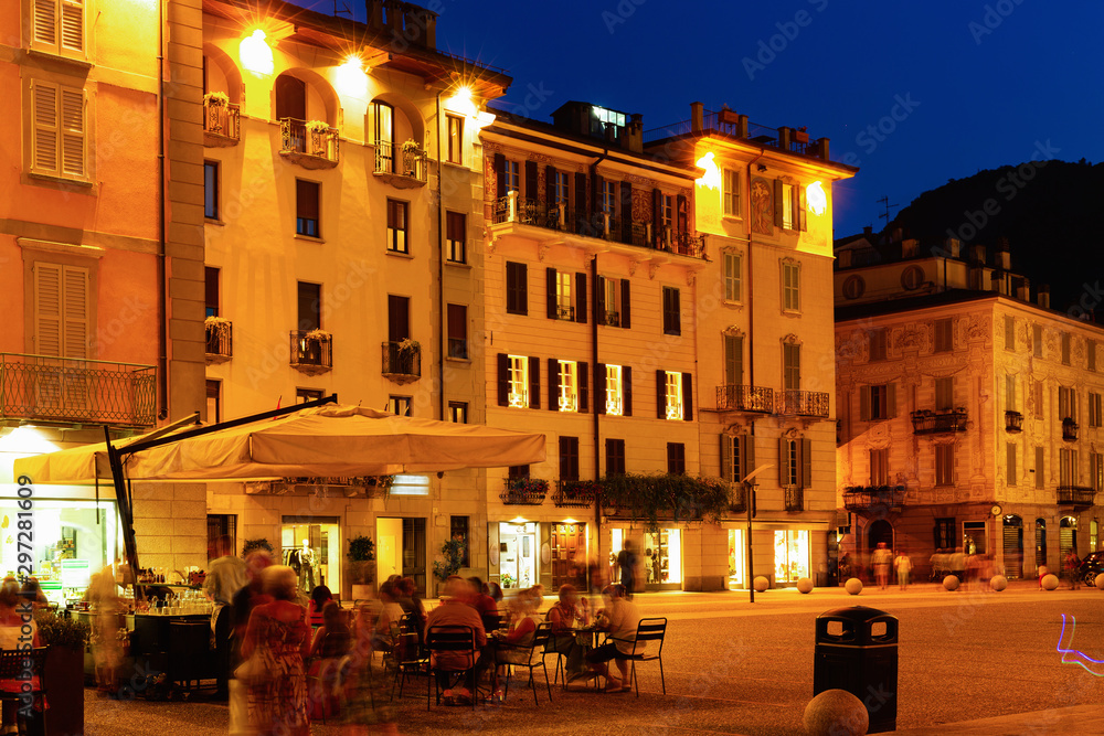 Streets and buildings of Como city in evening near mountains in Italy