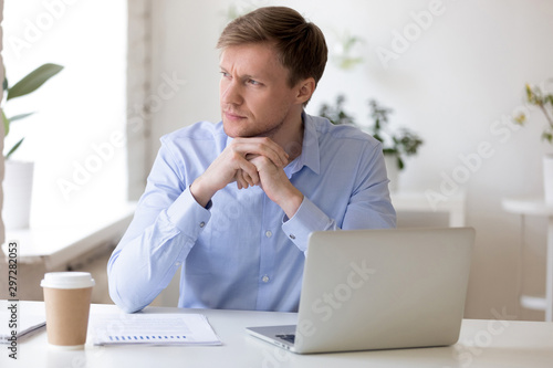 Pensive businessman distracted from job looking away. photo