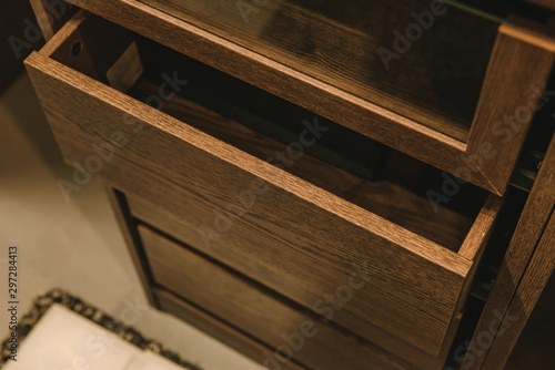 Wooden cupboard with opened empty drawer.