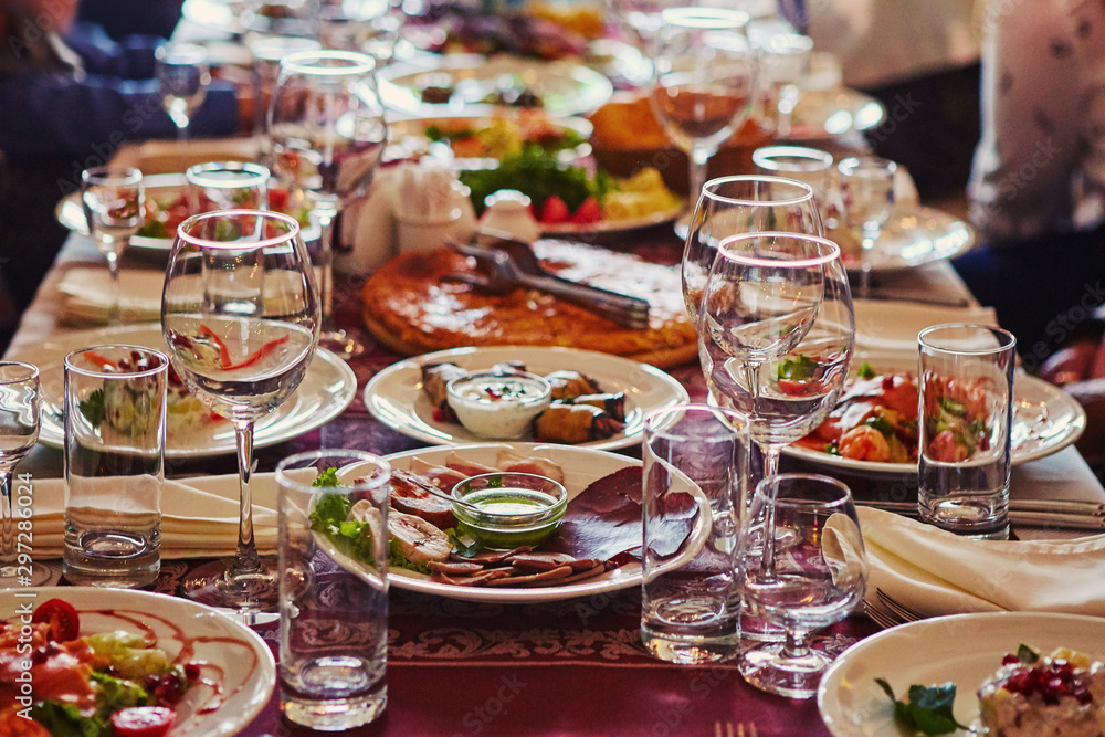 A group of people at a long table with food. The concept for the joint celebration of memorable dates or holidays