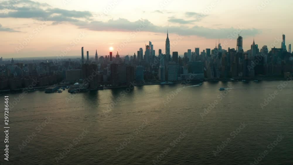 Aerial fly over East River towards midtown Manhattan skyline at sunset Aerial fly over East River towards midtown Manhattan skyline at sunset