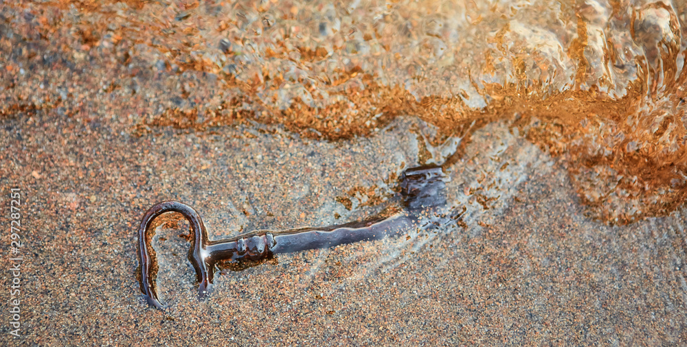 Ancient iron key, the sea washed up on the sand. Ancient iron key, the sea washed up on the sand.