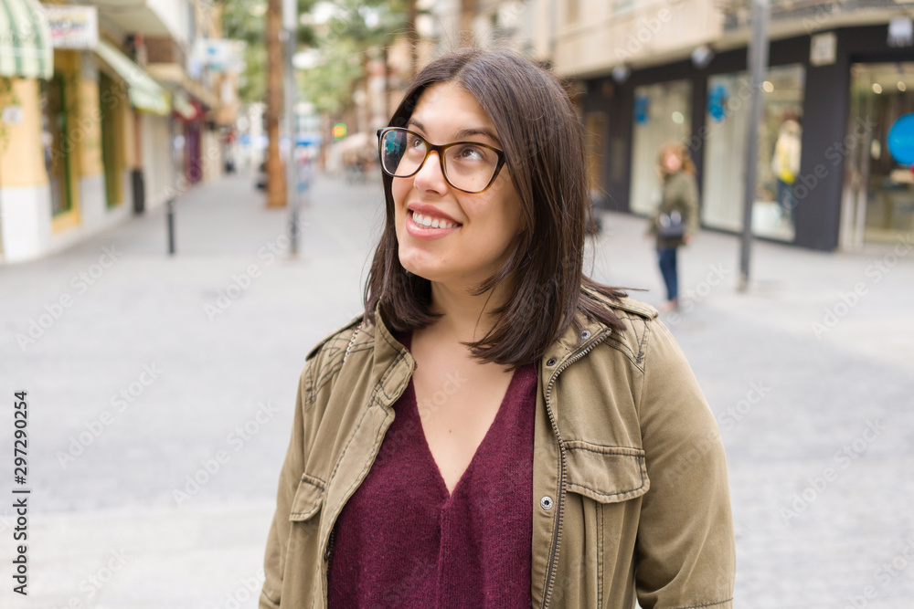 Fototapeta premium Beautiful young woman wearing glasses smiling confident at the streets of the town