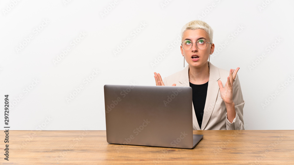 Teenager girl with short hair with a laptop frustrated by a bad situation Teenager girl with short hair with a laptop frustrated by a bad situation
