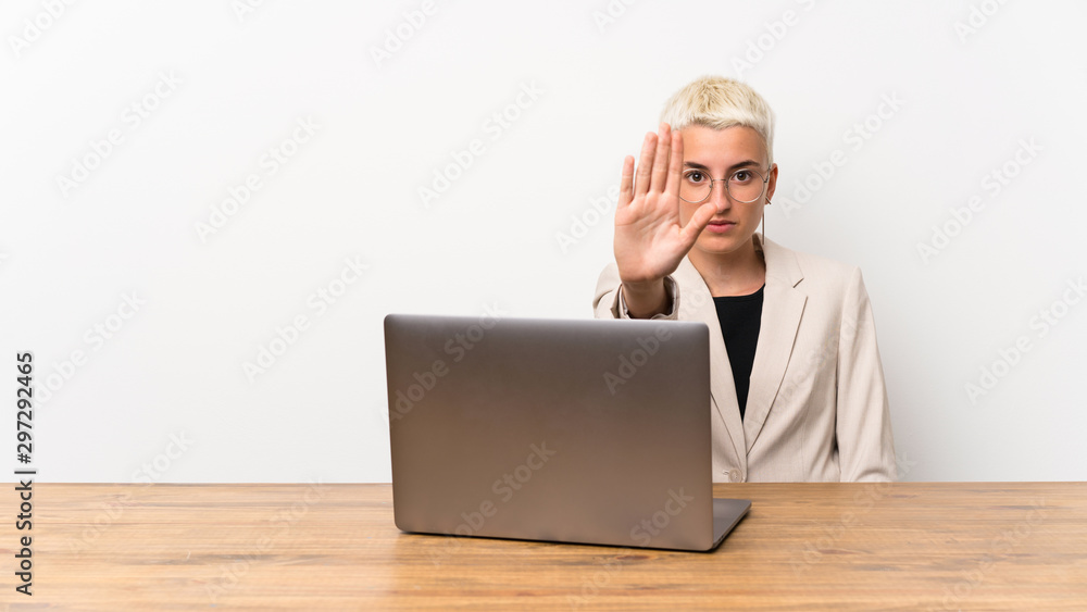 Teenager girl with short hair with a laptop making stop gesture Teenager girl with short hair with a laptop making stop gesture