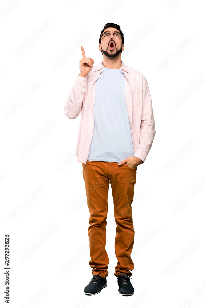 Fototapeta premium Full-length shot of Handsome man with beard pointing up and surprised over isolated white background