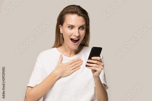 Excited young woman shocked by pleasant text on cellphone