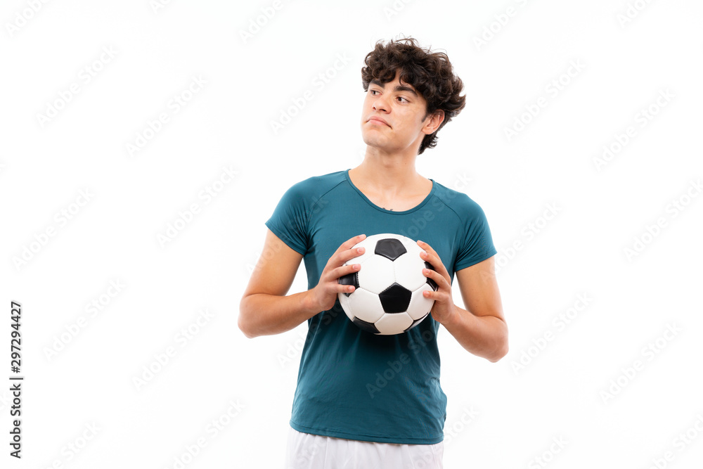 Young football player man over isolated white wall making doubts gesture while lifting the shoulders