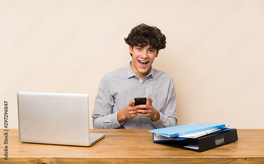 Young student man with a laptop surprised and sending a message Young student man with a laptop surprised and sending a message