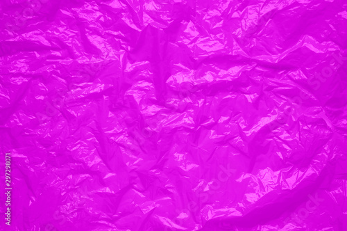 Fotografi Pink cellophane sheet with shiny crumpled texture, abstract neon background