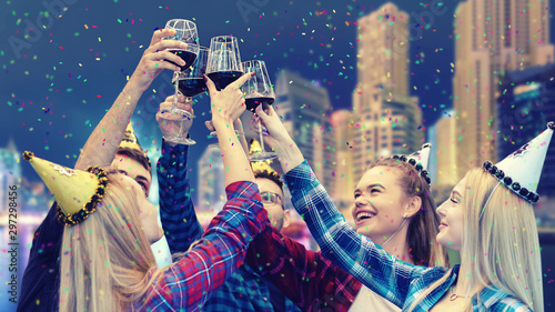 Canvas Print Happy young friends having fun drinking red wine at rooftop party