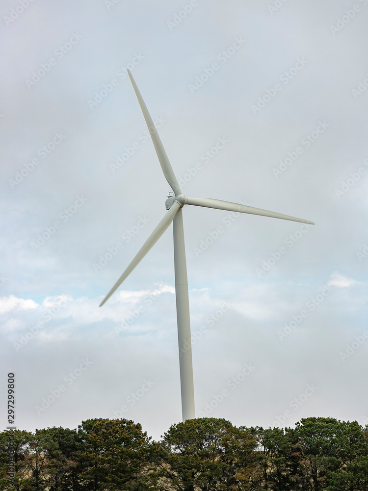 A large wind turbine moving to create kinetic energy for renewable energy supply on a cloudy day located southeast of Lake George and north of Bungendore in New South Wales, Australia A large wind turbine moving to create kinetic energy for renewable energy supply on a cloudy day located southeast of Lake George and north of Bungendore in New South Wales, Australia