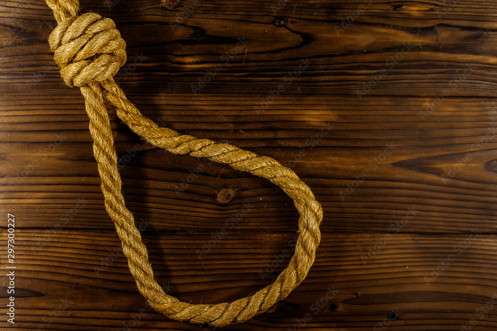 Deadly loop of rope on a wooden background. Concept of death penalty or suicide