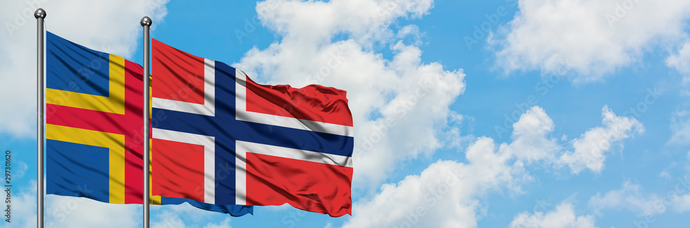 Fototapeta premium Aland Islands and Bouvet Islands flag waving in the wind against white cloudy blue sky together. Diplomacy concept, international relations.