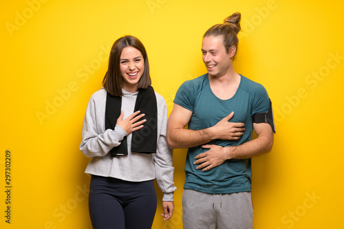 Group of athletes over yellow background smiling a lot while putting hands on chest
