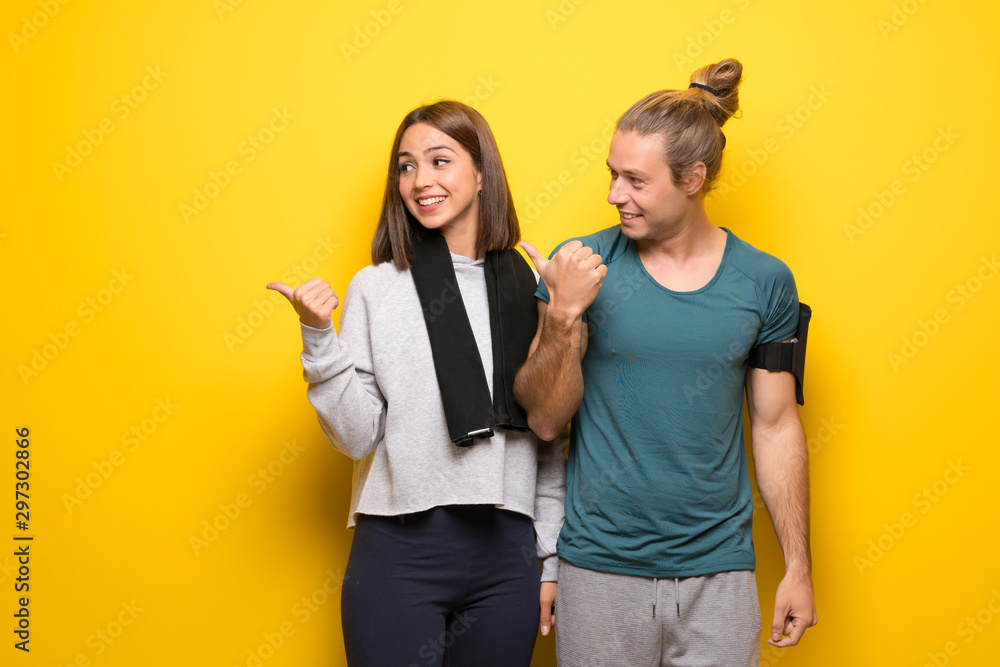 Group of athletes over yellow background pointing to the side to present a product Group of athletes over yellow background pointing to the side to present a product