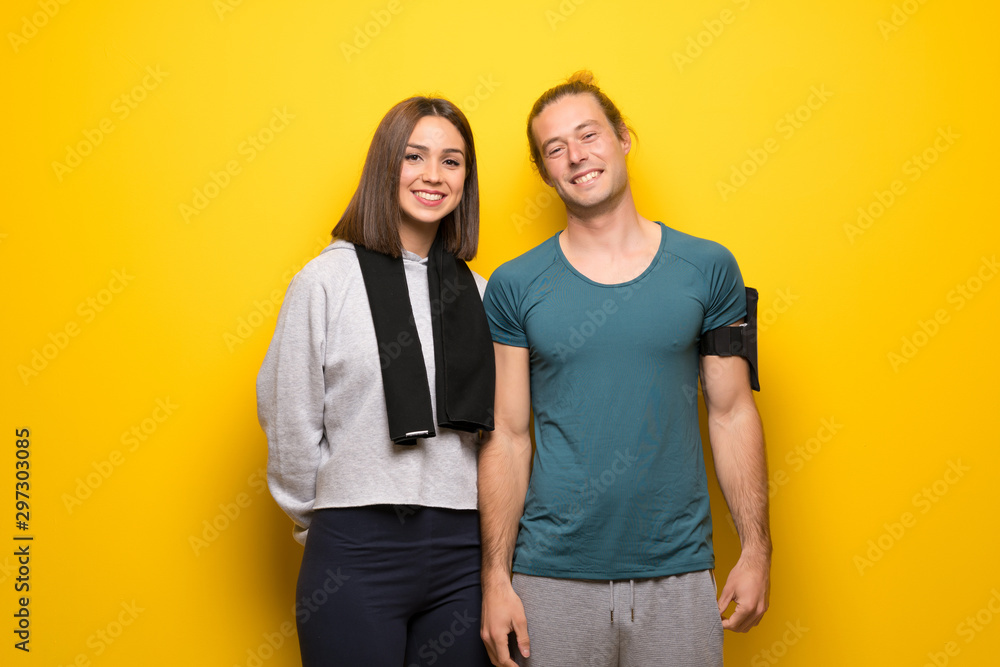Group of athletes over yellow background smiling Group of athletes over yellow background smiling