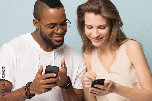 Happy multiethnic couple share online deals on smartphones