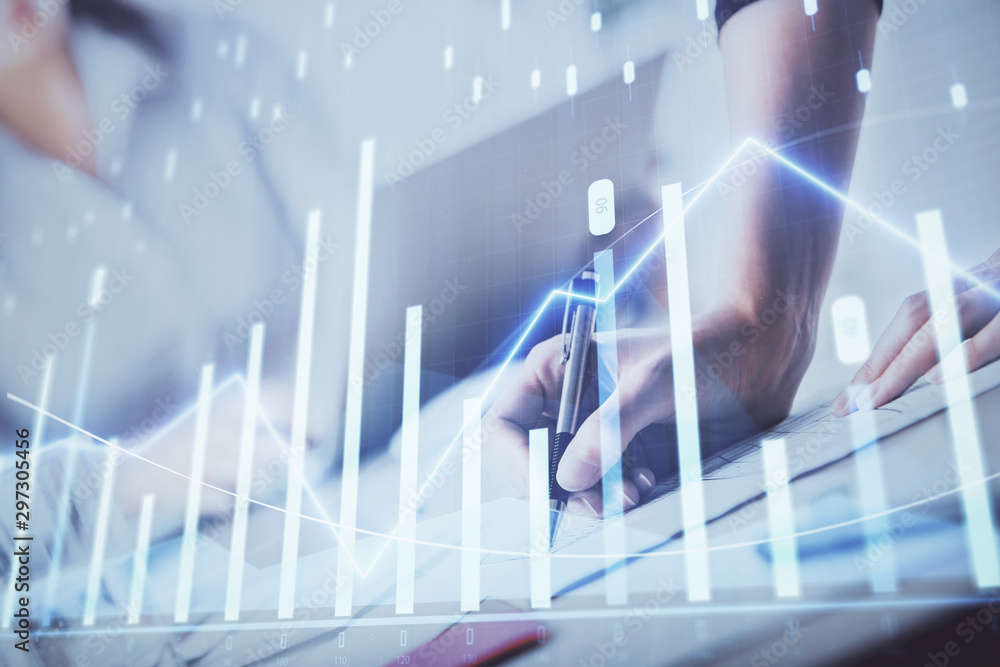 A woman hands writing information about stock market in notepad. Forex chart holograms in front. Concept of research. Double exposure A woman hands writing information about stock market in notepad. Forex chart holograms in front. Concept of research. Double exposure