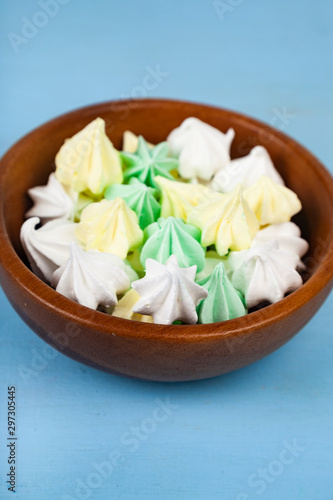 Meringue in a bowl on a wooden background.
