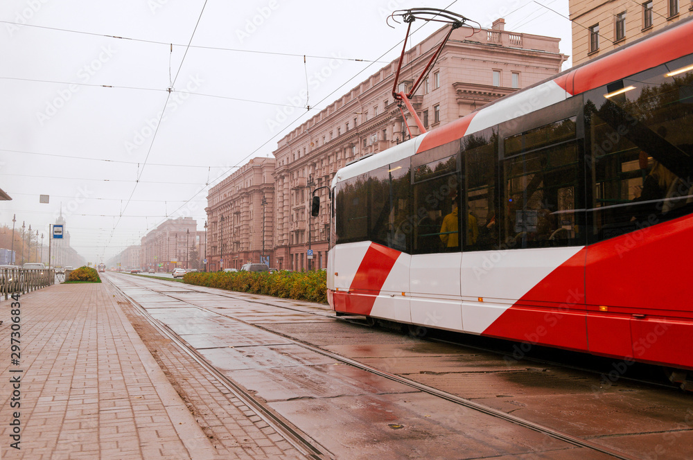 red tram on St. Petersburg street on a rainy autumn day, October 2019, buildings