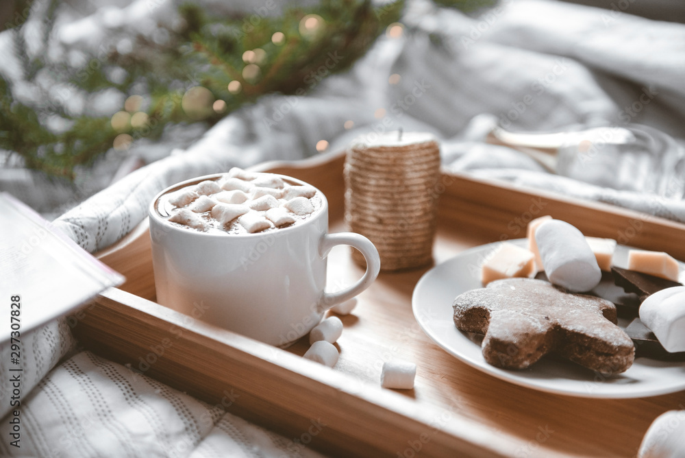 Cup of coffee, cocoa with marshmallows on a tray with cookies on a light blanket, fir branches with lights in the background, Cup of coffee, cocoa with marshmallows on a tray with cookies on a light blanket, fir branches with lights in the background,