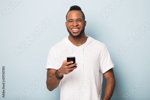 Overjoyed african American male client using modern cellphone