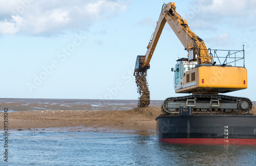 Dredger dumping sand on a bank photo