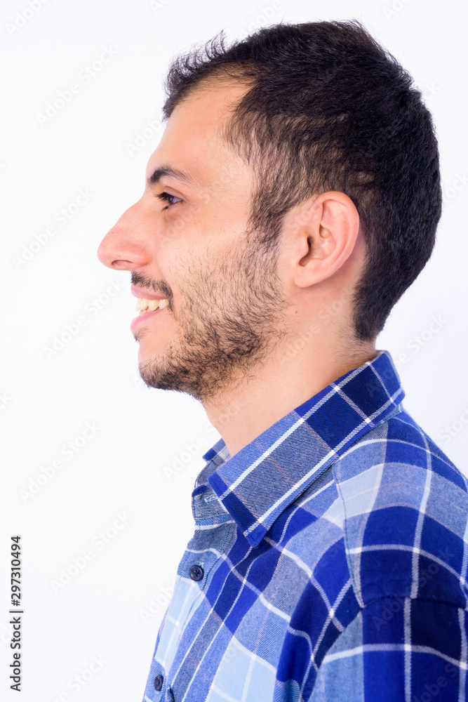 Closeup profile view of happy young bearded Persian hipster man smiling Closeup profile view of happy young bearded Persian hipster man smiling