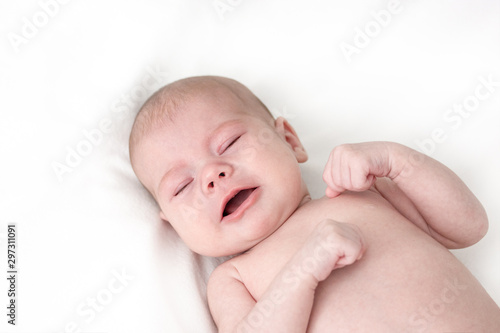 Little baby boy girl crying on white. Newborn baby less than a year with clenched fists